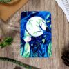illustration douce et magique à l’aquarelle, avec une petite sorcière vêtue d’une robe verte aux manches amples.